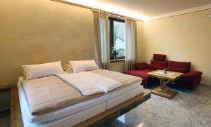 ein Schlafzimmer mit einem Bett, einem Tisch und einem Stuhl in der Unterkunft Gästehaus Alte Glaserei in Neustadt an der Weinstraße