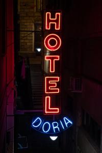 a red neon sign that says hot drop zone at Hotel Doria in Genoa