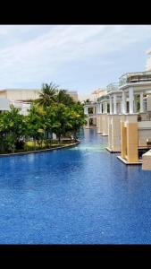 une grande piscine d'eau bleue à côté des bâtiments dans l'établissement Hua Hin Blue Lagoon, à Cha Am