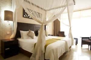 a bedroom with a bed with a canopy at Victoria Falls Rainbow Hotel in Victoria Falls
