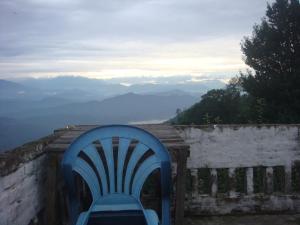 una silla azul sentada en un balcón con vistas en Shiva Guest House, en Dhulikhel