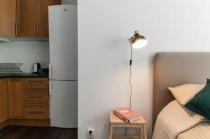 a small kitchen with a refrigerator next to a bed at Cozy Studio in Uppsala