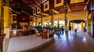 a lobby with tables and chairs in a building at Pandanus Resort in Mui Ne