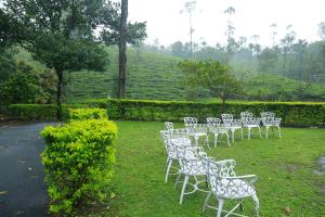 a row of white chairs sitting in the grass at Saj Vagamon Hideout in Vagamon