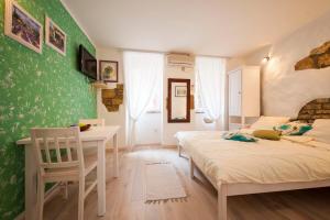 1 dormitorio con 2 camas, mesa y sillas en Apartments Tanga, en Rovinj