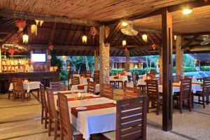 ein Restaurant mit Tischen und Stühlen und eine Bar in der Unterkunft Cocotinos Manado in Manado