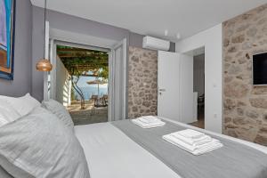 a bedroom with a white bed with a view of the ocean at Villa Mate in Zaostrog