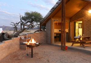 a house in the desert with a fire pit at Desert Camp in Sesriem