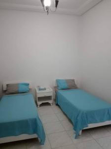 two beds sitting next to each other in a room at Studio en plein zone touristique avec wifi, IPTV et Clim in Sousse