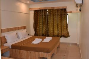 a bedroom with a bed with two towels on it at Riverside Inn in Koynanagar