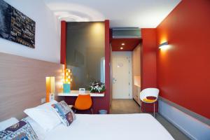 Habitación de hotel con cama y pared roja en iH Hotels Agrigento Kaos Resort, en Agrigento