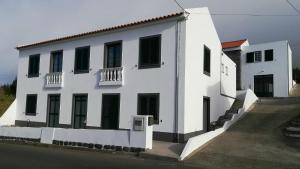 ein weißes Gebäude mit schwarzen Türen und Fenstern in der Unterkunft BELO CAMPO - Ilha do Faial (Horta) in Castelo Branco