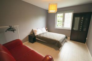 1 dormitorio con cama, sofá y ventana en Dom nad Lubie en Lubieszewo