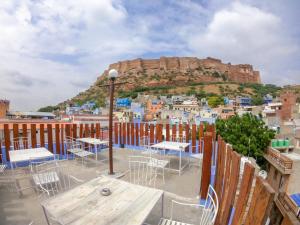 a balcony with tables and chairs and a view of a city at Kings Retreat Jodhpur in Jodhpur