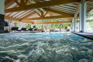 una piscina en una casa con techo de madera en Hotel Cirelle Suite & Spa, en Canazei