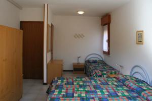a hotel room with two beds and a window at Carinzia in Lignano Sabbiadoro