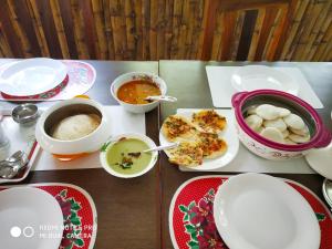 a table with plates of food and bowls of soup at Bamboo Creak in Thekkady