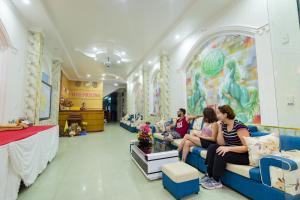 a group of people sitting on a couch in a waiting room at Phoenix Flower Hotel in Cat Ba