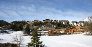 een resort in de bergen met sneeuw op de grond bij Joli Studio à la Montagne in Auron