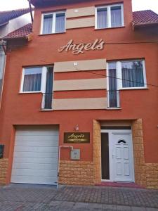 un edificio de ladrillo con un signo de ángeles en él en ANGEL´S VENDÉGHÁZ en Eger