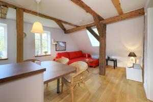 ein Wohnzimmer mit einem roten Sofa und einem Tisch in der Unterkunft Alte Schmiede Bleckede in Bleckede