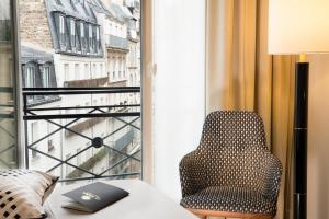 a chair in a room with a window at Le Tsuba Hotel in Paris
