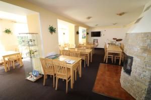 a restaurant with wooden tables and chairs and a fireplace at Penzion U Elišky Bedřichov V Jizerských Horách in Bedřichov