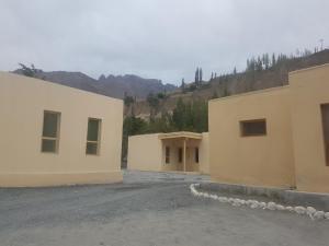 eine Gruppe von Gebäuden mit Bergen im Hintergrund in der Unterkunft Khunjerab Hotel Sost in Gircha