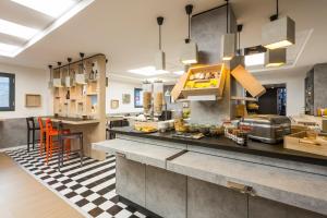 a large kitchen with a counter and a table at ibis Bordeaux Centre - Gare Saint-Jean in Bordeaux