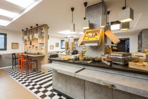 a large kitchen with a counter and a table at ibis Bordeaux Centre - Gare Saint-Jean in Bordeaux