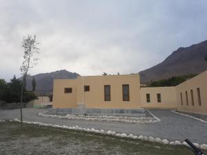 a large building with mountains in the background at Khunjerab Hotel Sost in Gircha