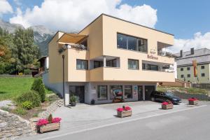 a large building with flowers in front of it at Apart Bellevue in Pettneu am Arlberg