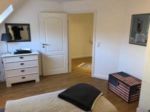 a bedroom with a bed and a dresser with a mirror at Hyggehus in Humptrup