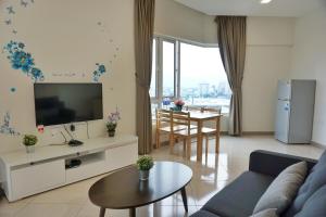 a living room with a couch and a tv and a table at PM Octagon Ipoh Suites & Apartment 3 in Ipoh