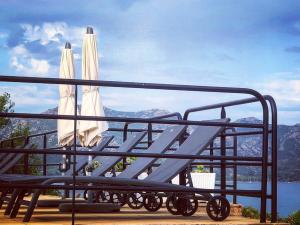 a bench with two umbrellas and a view of the mountains at Résidence Costa d'Oru in Saint-Florent