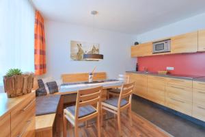 佩特诺伊阿尔贝格Apart Bellevue的配有木制橱柜、桌子和椅子的厨房 更多35张照片