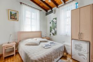 a bedroom with a bed and a cabinet and windows at Cypriot Swallow Boutique Hotel in North Nicosia