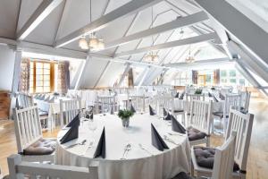 a large dining room with a white table and chairs at Dolina Charlotty Resort&Spa in Słupsk