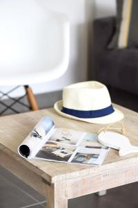 - une table avec un chapeau et des magazines dans l'établissement Le Clos des Vieux Moulins, à La Flotte