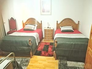 a bedroom with two beds and a dresser at Casa Rafael in Belmonte