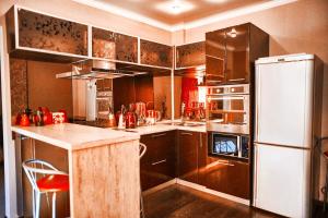 マグニトゴルスクにあるFive Stars Idealのキッチン(茶色のキャビネット、白い冷蔵庫付)