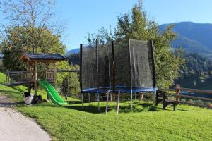 a playground with a green slide and a nets at Bauernhof Mödling in Hopfgarten im Brixental