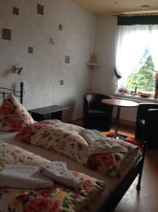 a bedroom with two beds and a table and a window at Privatvermietung Gründel in Thermalbad Wiesenbad
