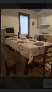einen Esstisch mit einem weißen Tischtuch drauf in der Unterkunft Casa Greta in Massarosa
