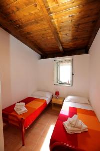 two beds in a room with a wooden ceiling at Residence San Salvatore in Palinuro
