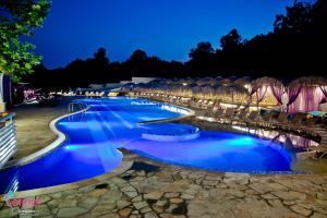 a row of pools at night with chairs and umbrellas at Elinor Complex in Haskovo