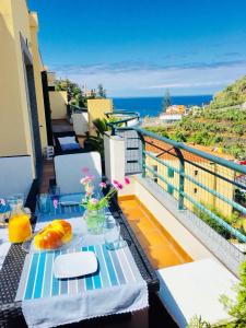 a table on a balcony with a view of the ocean at Apartment Villa Sol II in Ponta do Sol