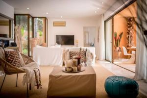 a living room with two chairs and a table and a couch at La Villa in Cala Vadella