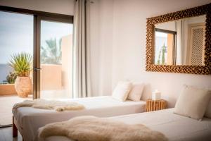 two beds in a room with a mirror on the wall at La Villa in Cala Vadella +24 photos