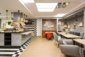 a restaurant with a counter and tables and chairs at ibis Bordeaux Centre - Gare Saint-Jean in Bordeaux
